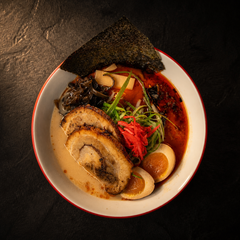 Ramen bowl with sliced pork, egg, seaweed, and green onions in rich broth