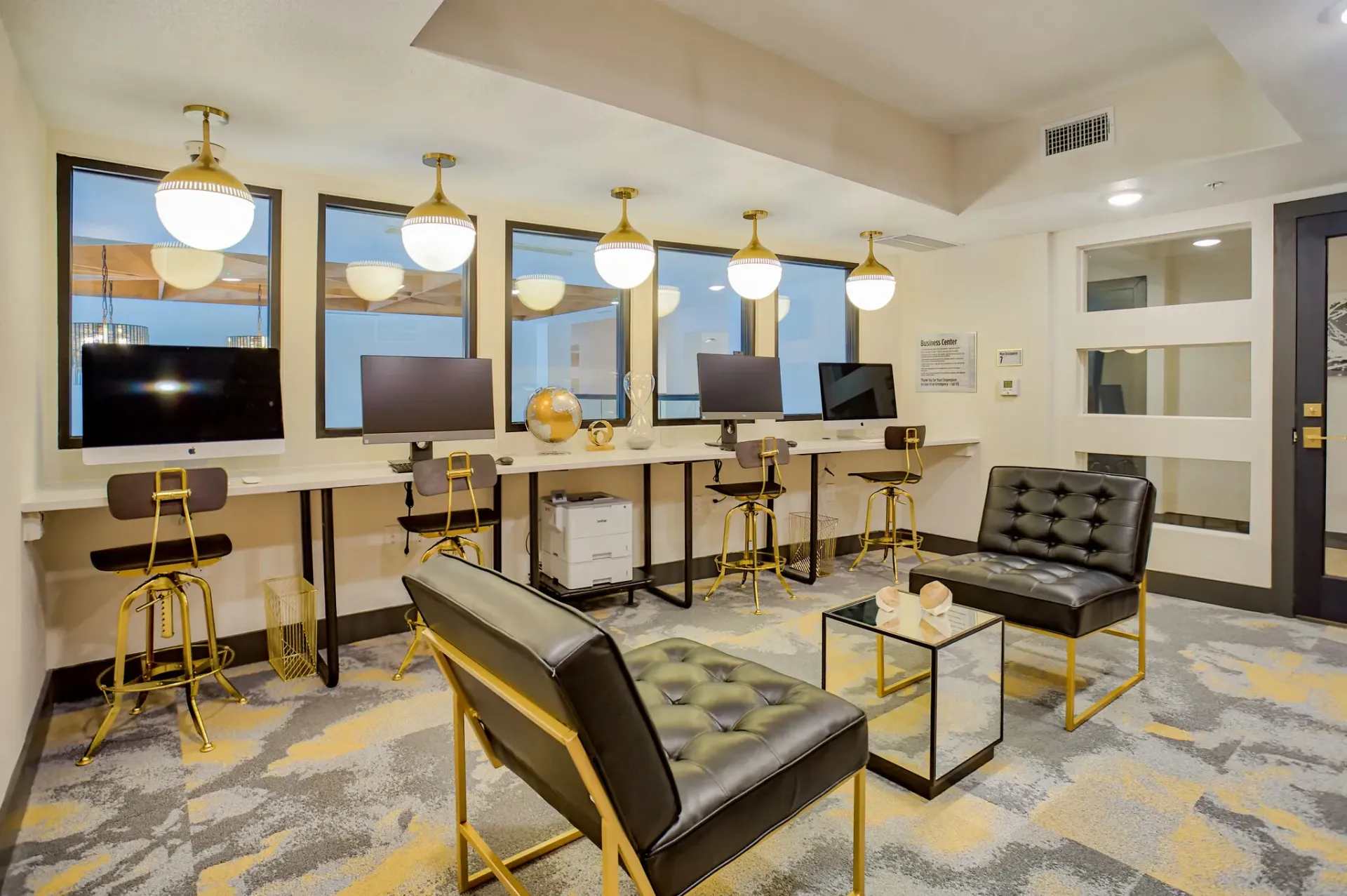 Modern resident common area with computer workstations and lounge seating.