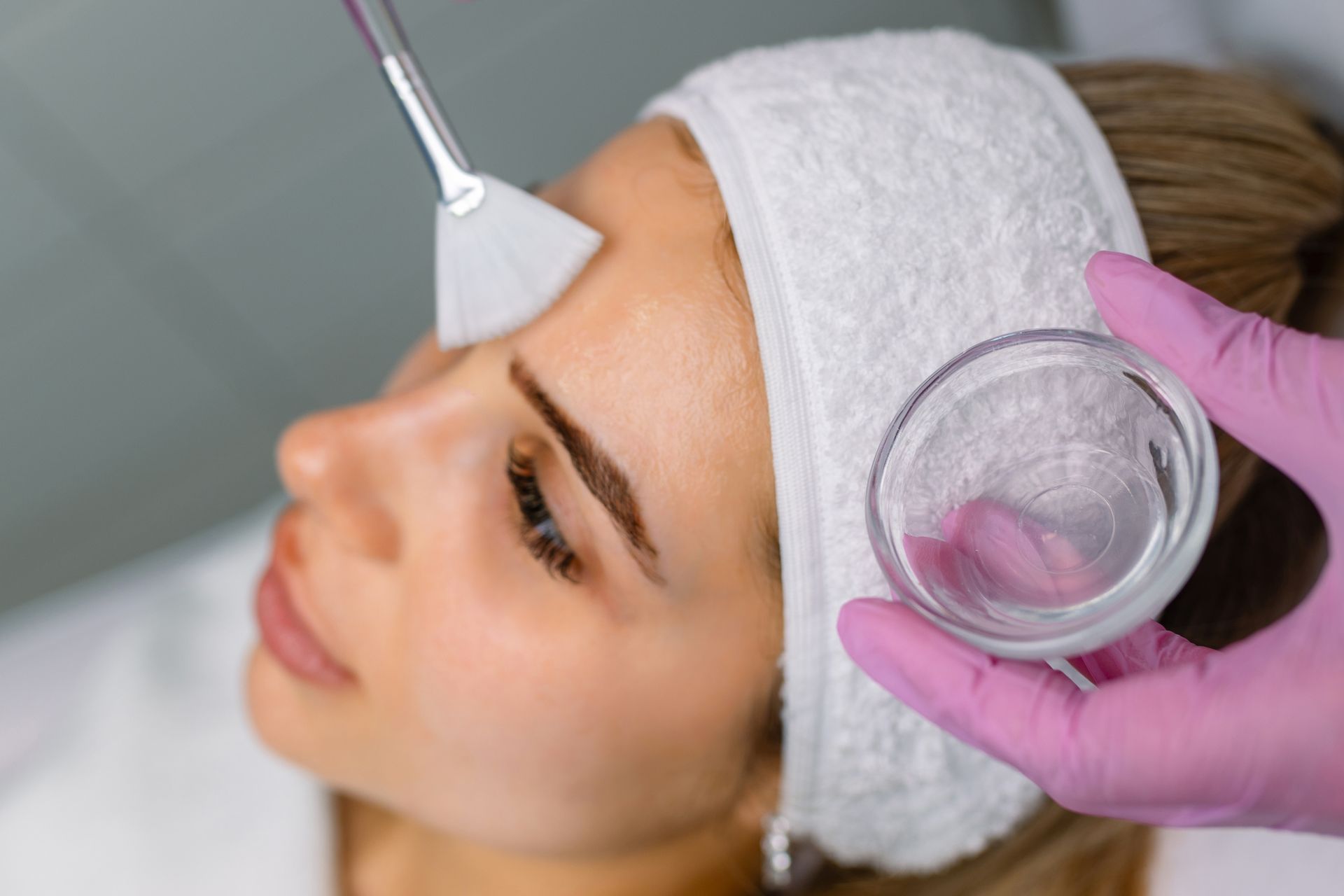 Facial skincare treatment with suction cup on woman’s forehead and cheek in a spa setting