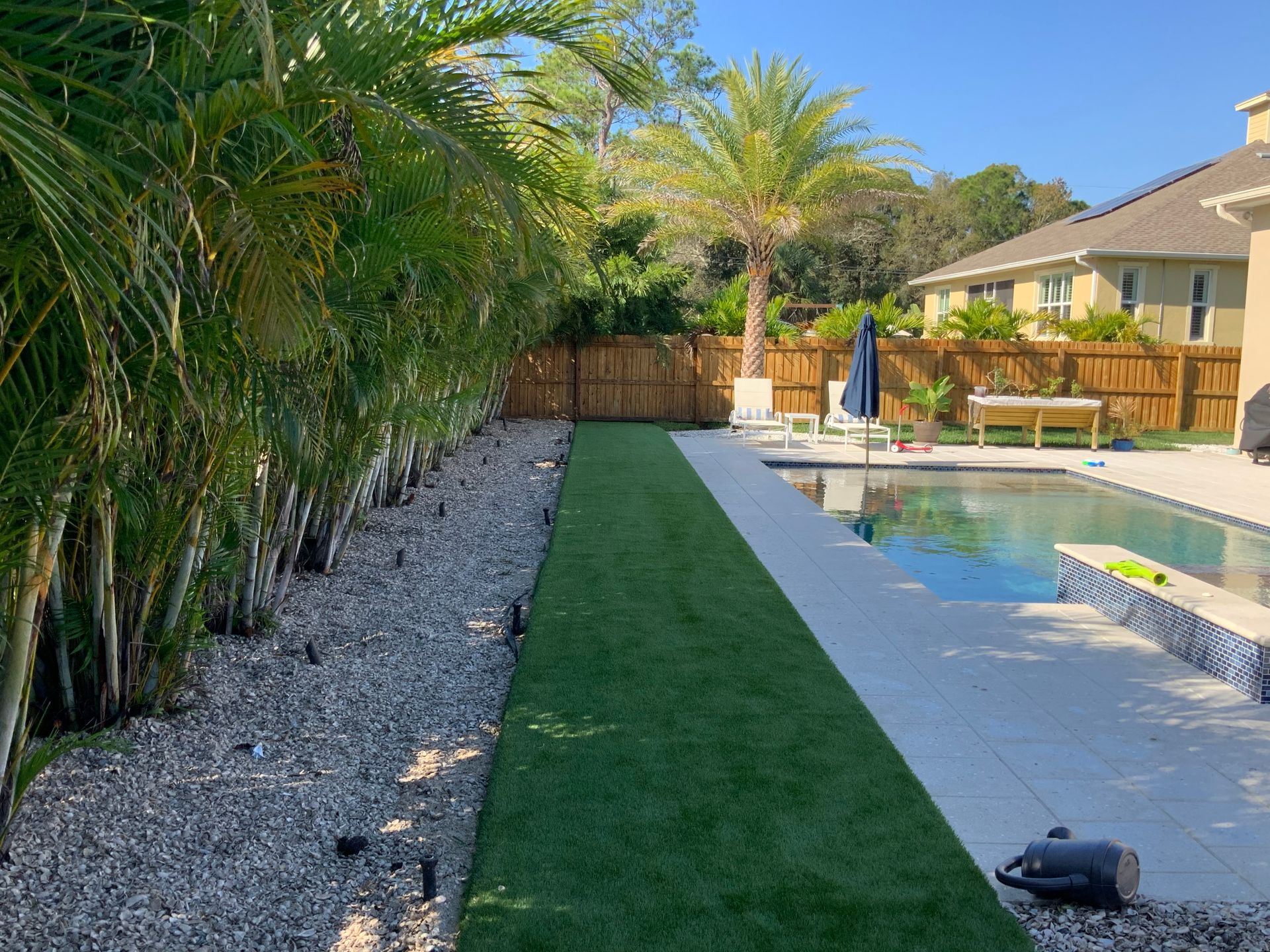 There is a swimming pool in the backyard of a house.