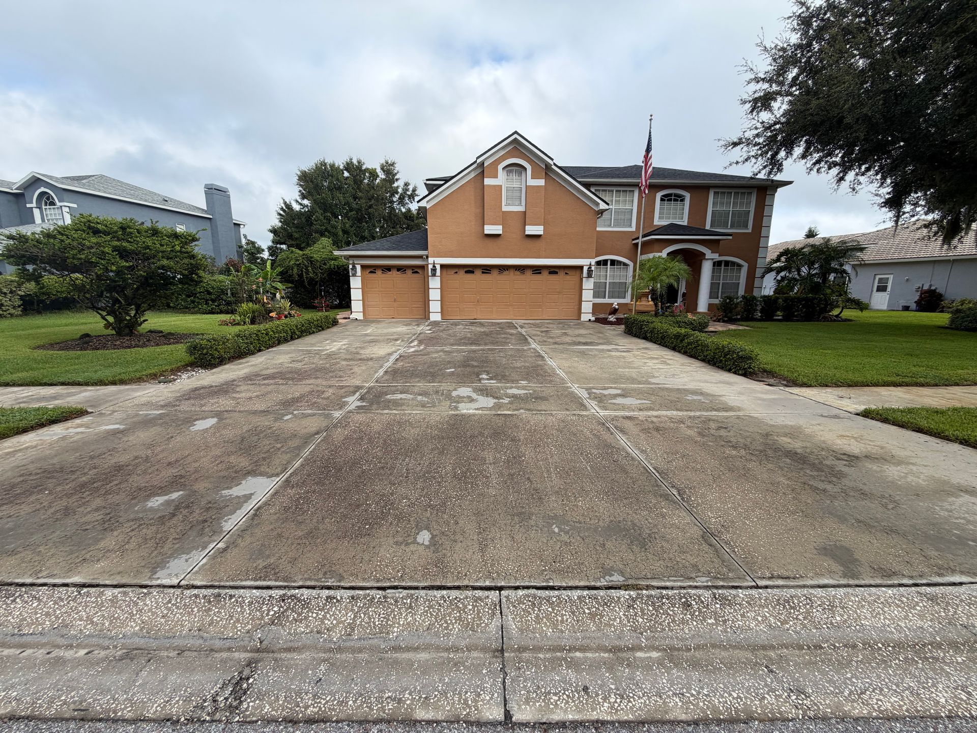 Stained, dirty concrete driveway covered in algae and grime before professional cleaning in Lutz, FL