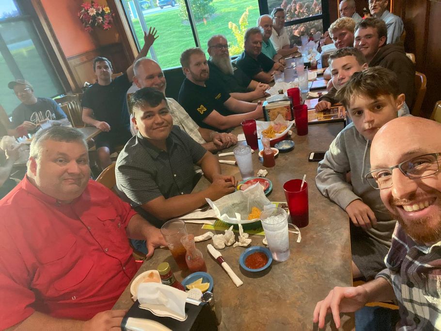 A group of people are sitting at a long table in a restaurant.