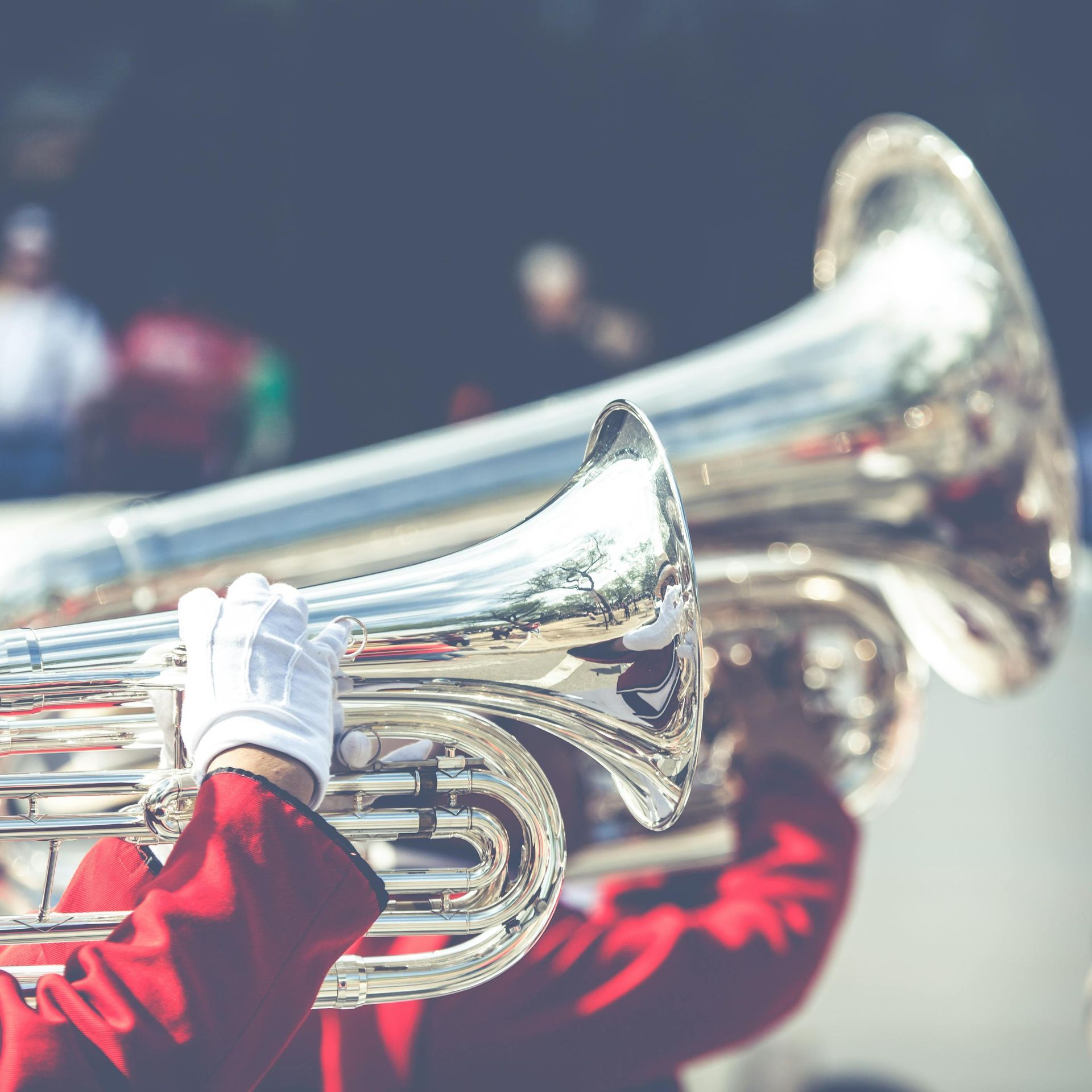 A man in a red jacket is playing a trumpet