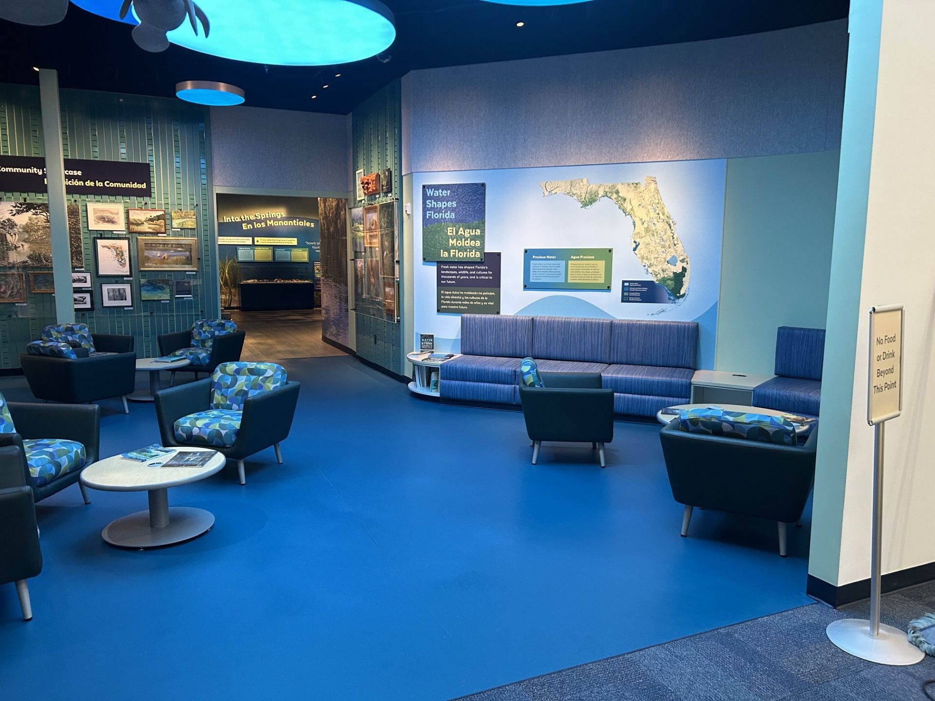 Blue-themed interior with seating. Florida map on wall. Open doorway to another exhibit.
