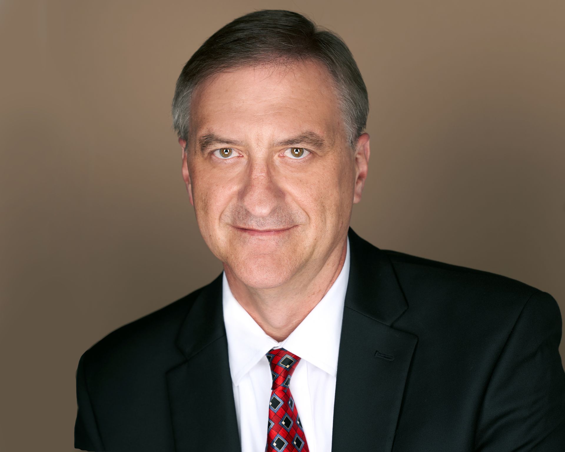 A man in a suit and tie is smiling for the camera.