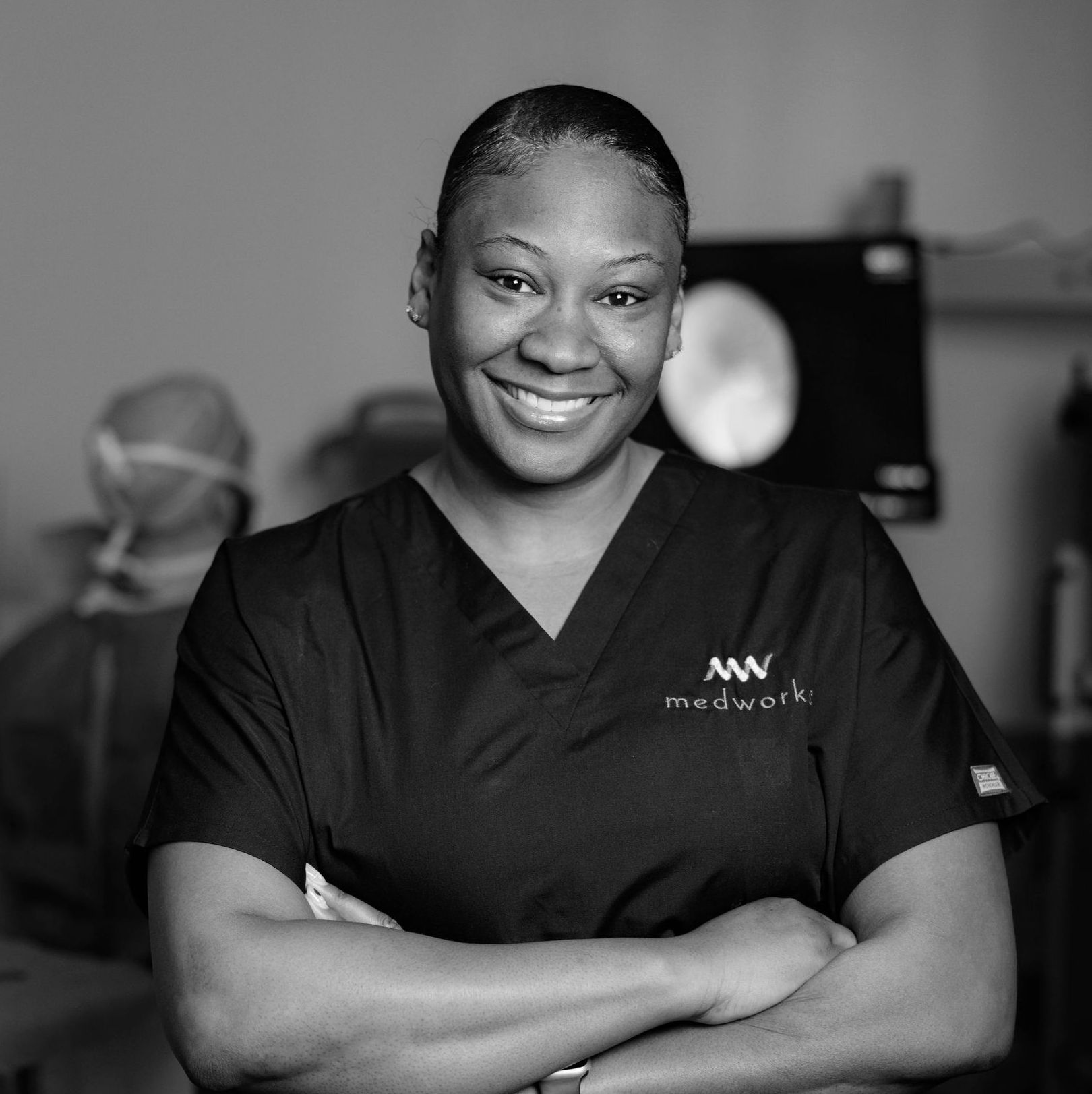 A black and white photo of a woman wearing a medwork scrub