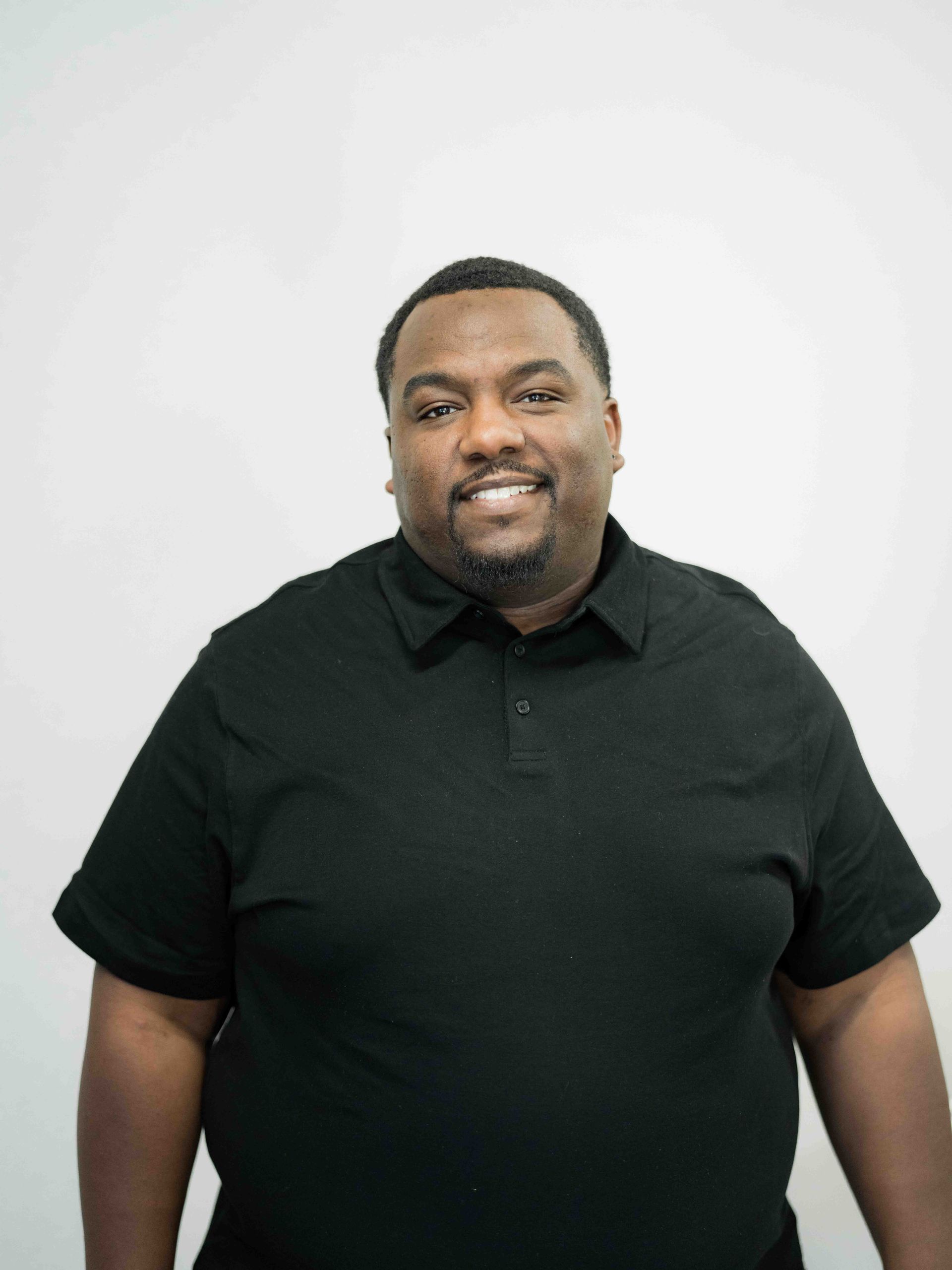 A man in a black shirt is smiling for the camera