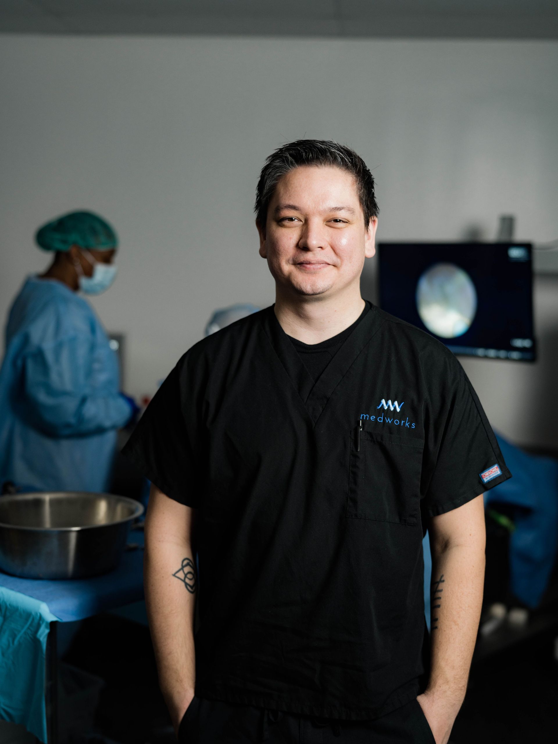 man standing in a medical room wearing a black shirt