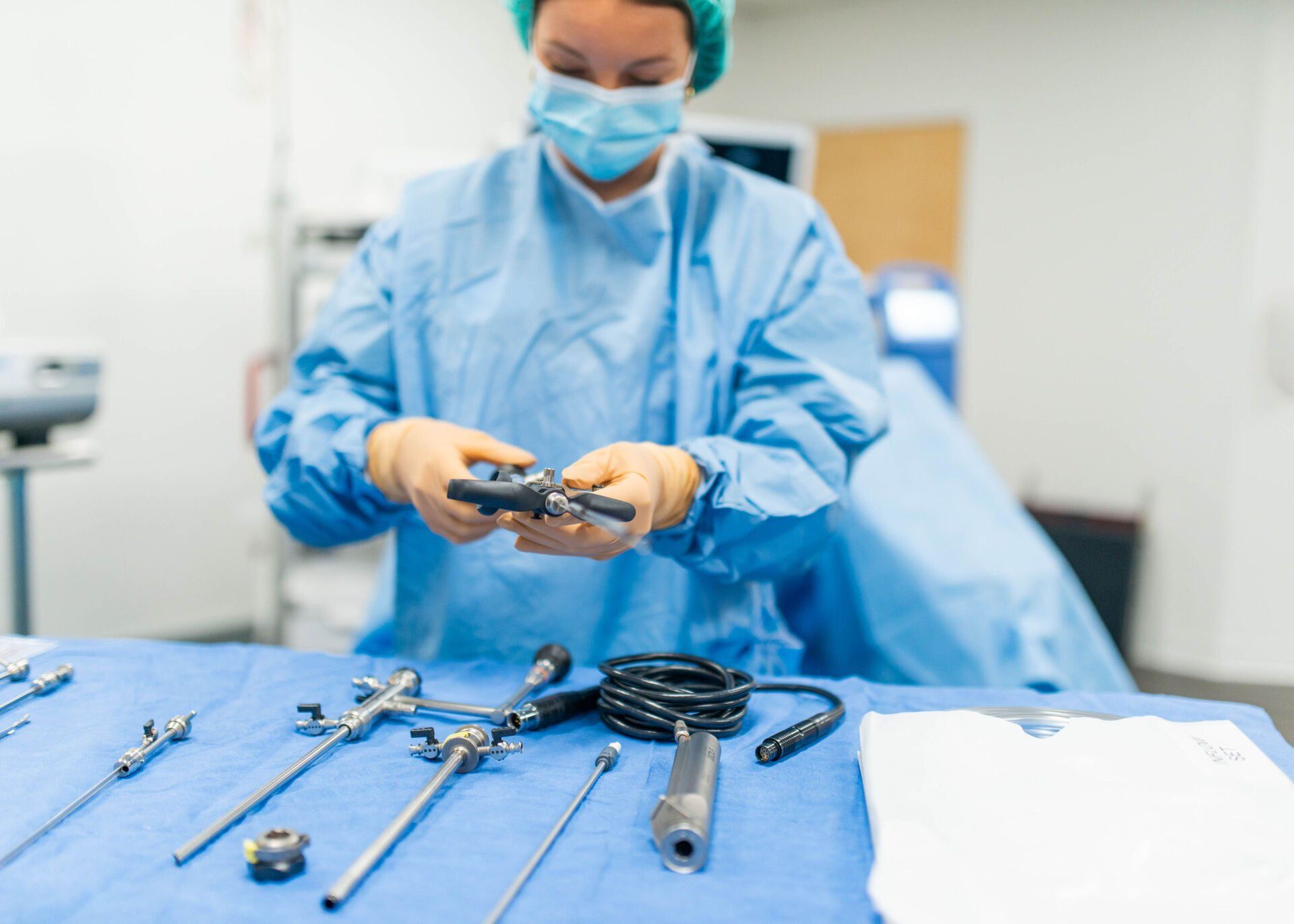 A female surgeon is holding a surgical instrument in an operating room.