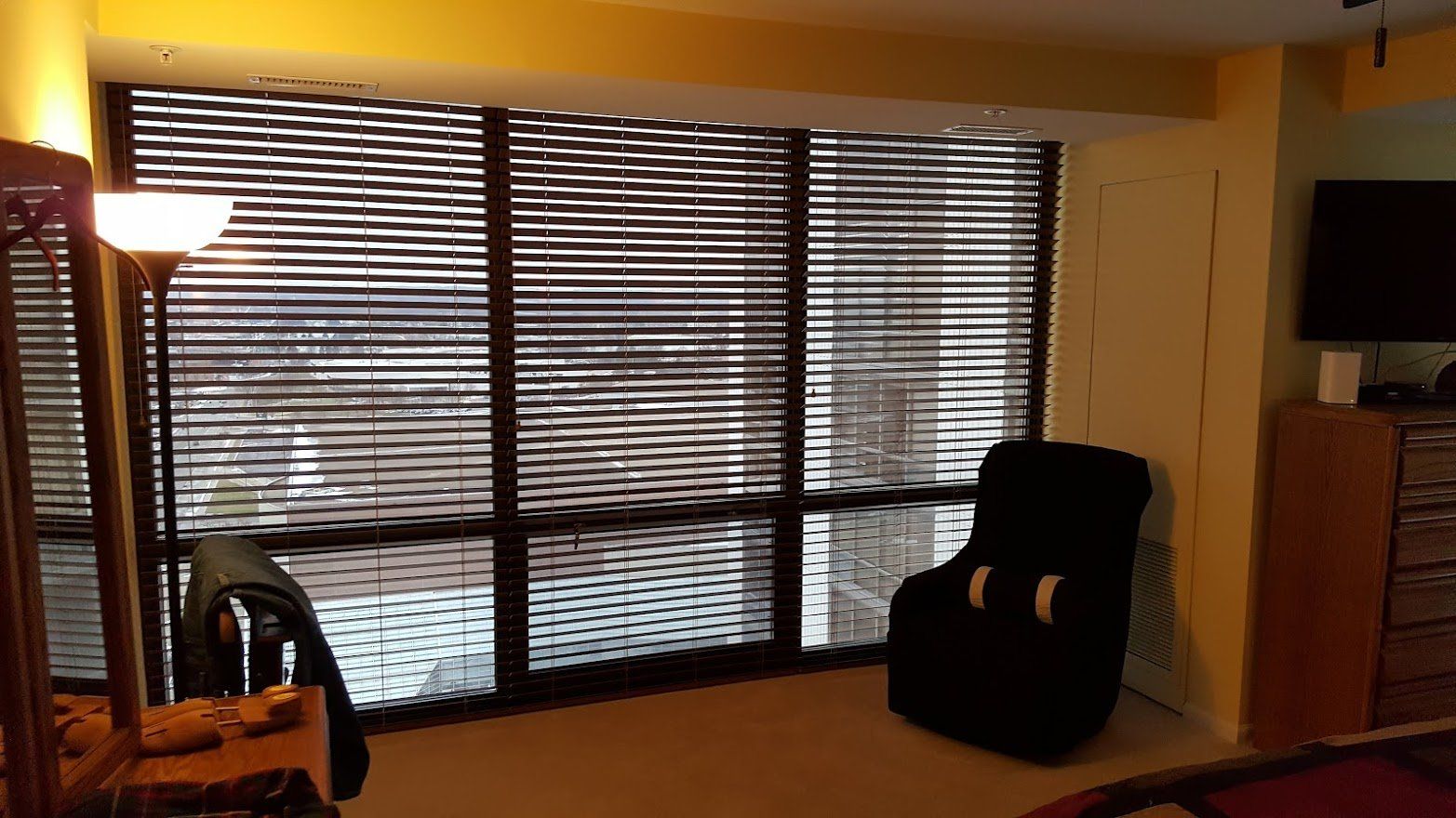 A living room with a large window and blinds.