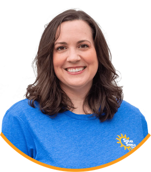 A woman wearing a blue shirt with a sun on it