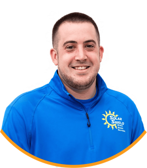 A man wearing a blue shirt that says solar shield