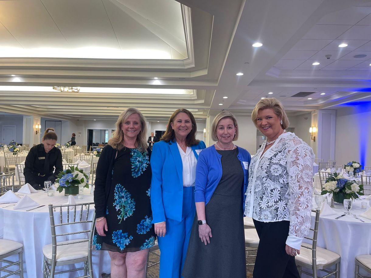 Family Investors Team posing at a formal banquet table in a brightly lit ballroom