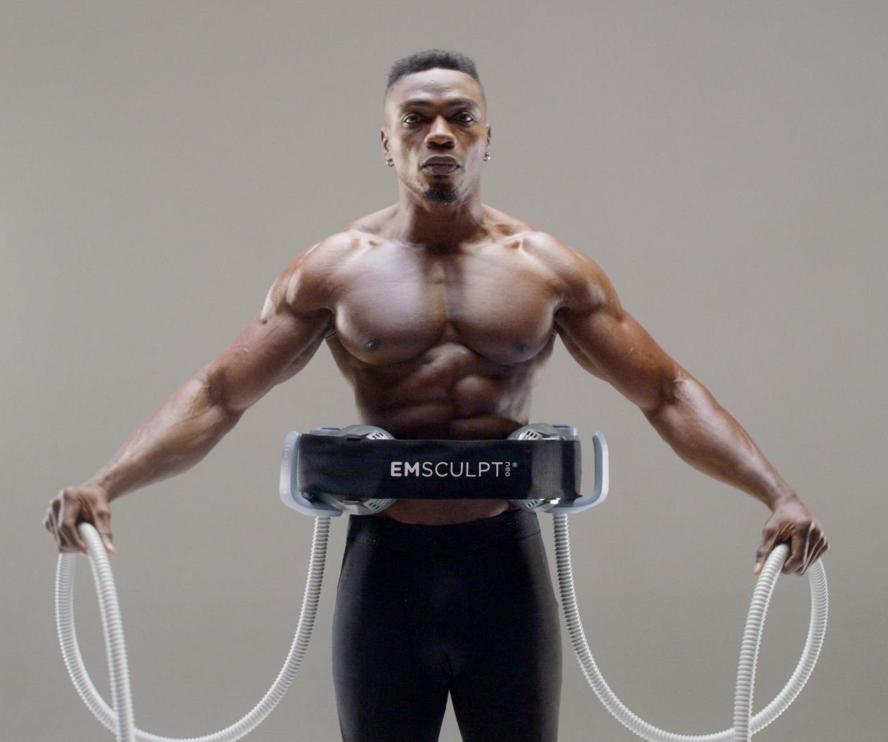 A muscular man is wearing a belt that says emsculpt on it