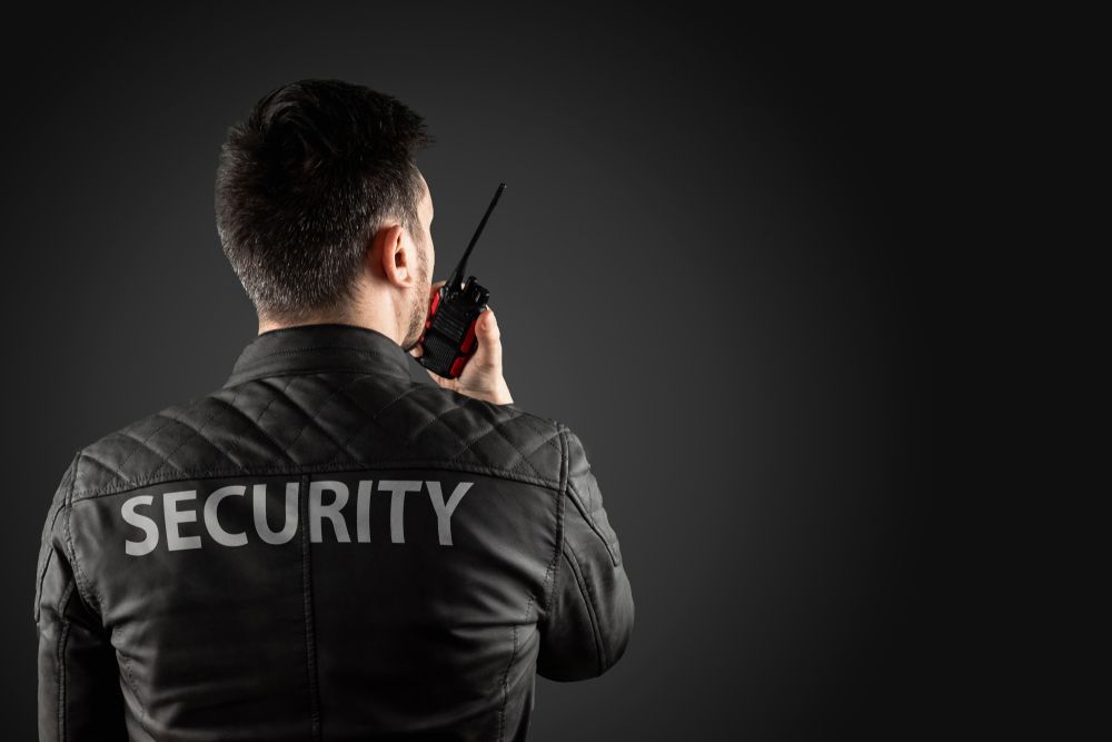 A Security Guard Is Talking On A Walkie Talkie — Asset Security Group In Coffs Harbour, NSW
