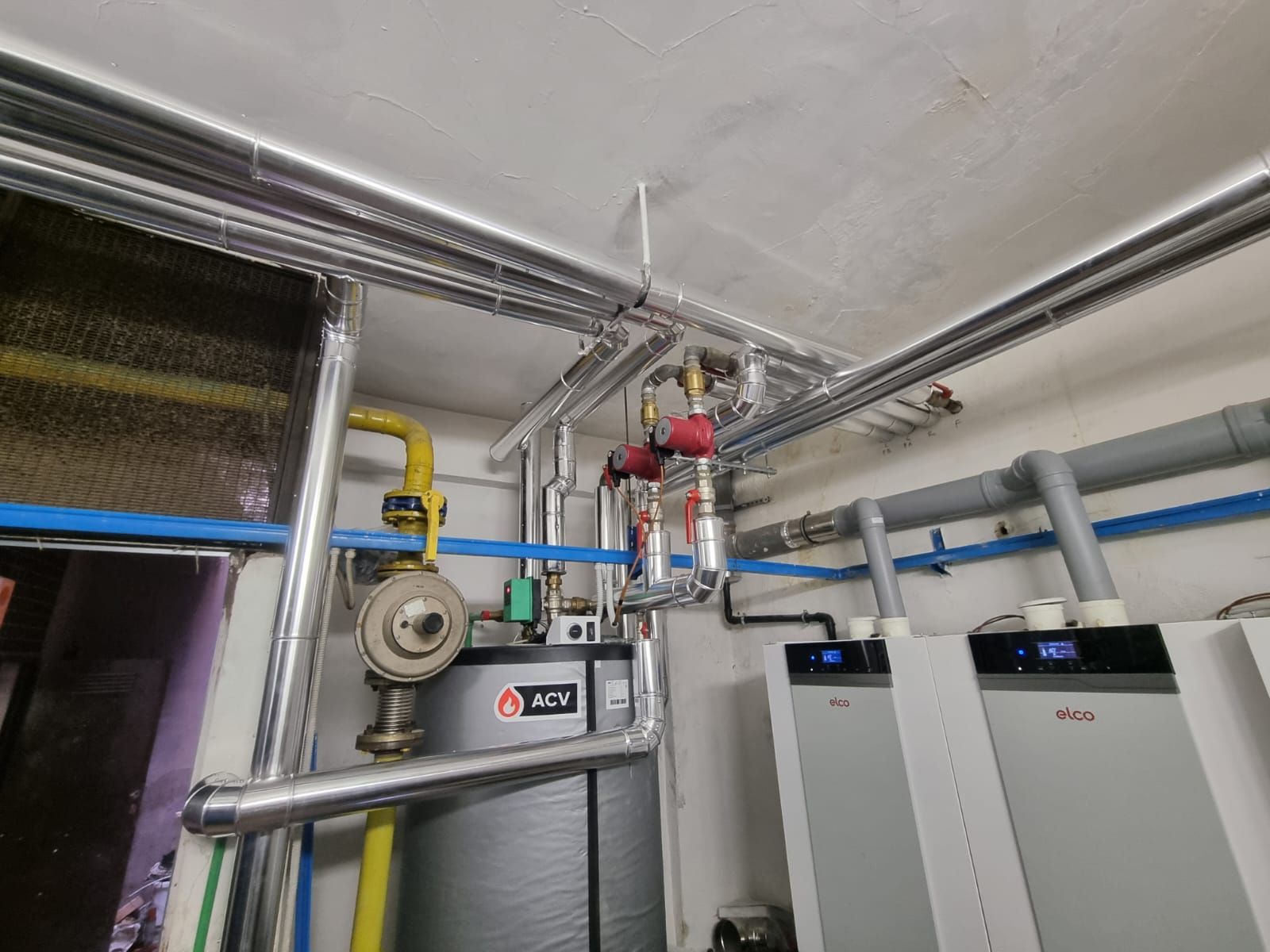 Una stanza con un sacco di tubi che pendono dal soffitto.