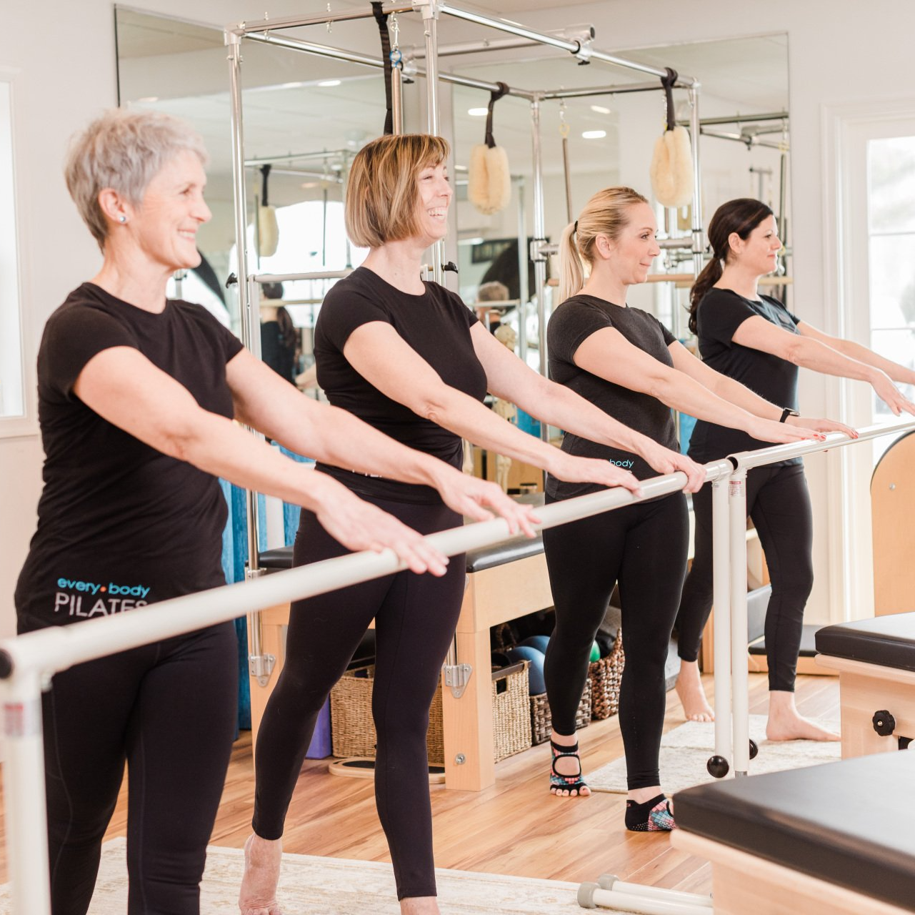 A group of women are practicing pilates in a gym