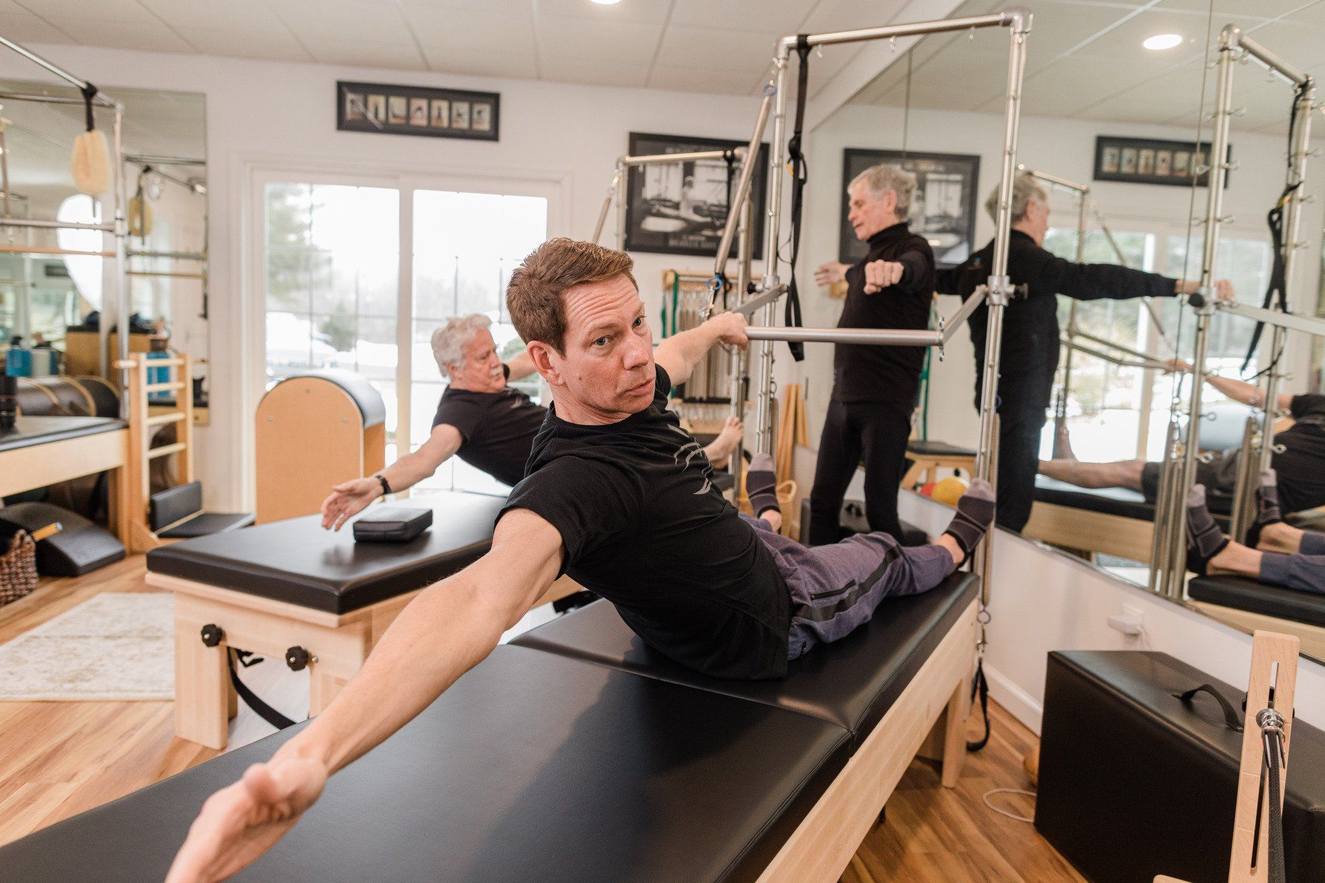 A man is doing exercises on a pilates machine in a gym.