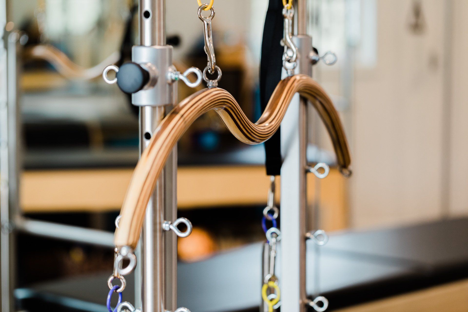 A close up of a pilates machine with a rope hanging from it.