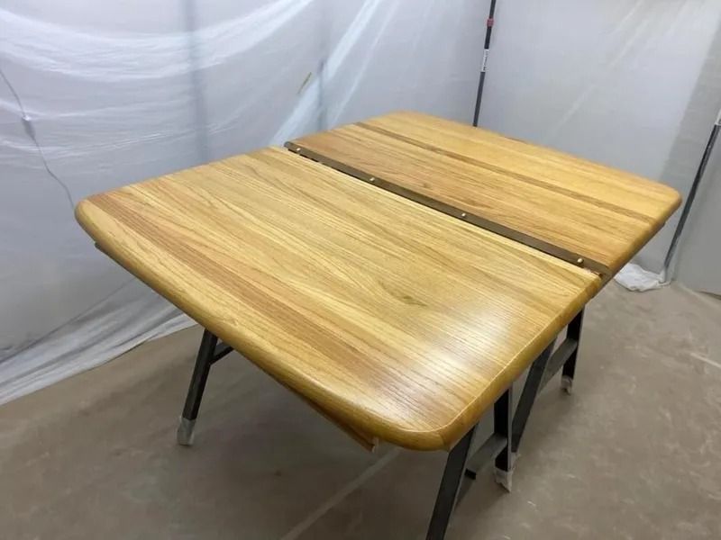 Two wooden classroom desks pushed together in a white-walled room