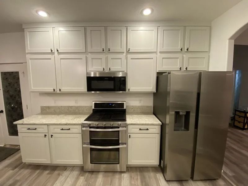 Modern kitchen with white cabinets, stainless steel appliances, and a stainless steel refrigerator