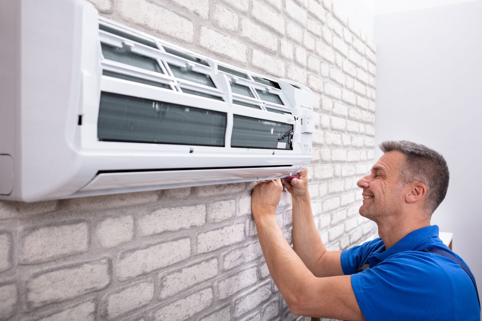 A man is working on an AC.