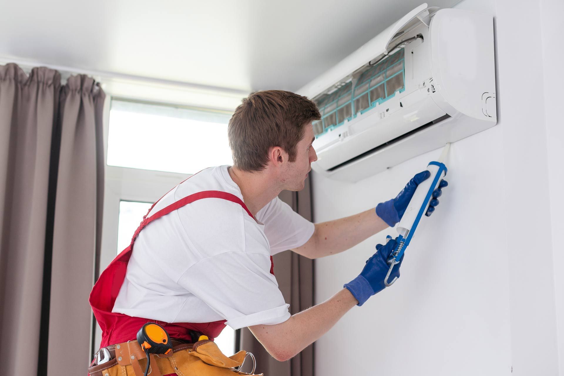 Technician service removing air filter of the air conditioner for cleaning.