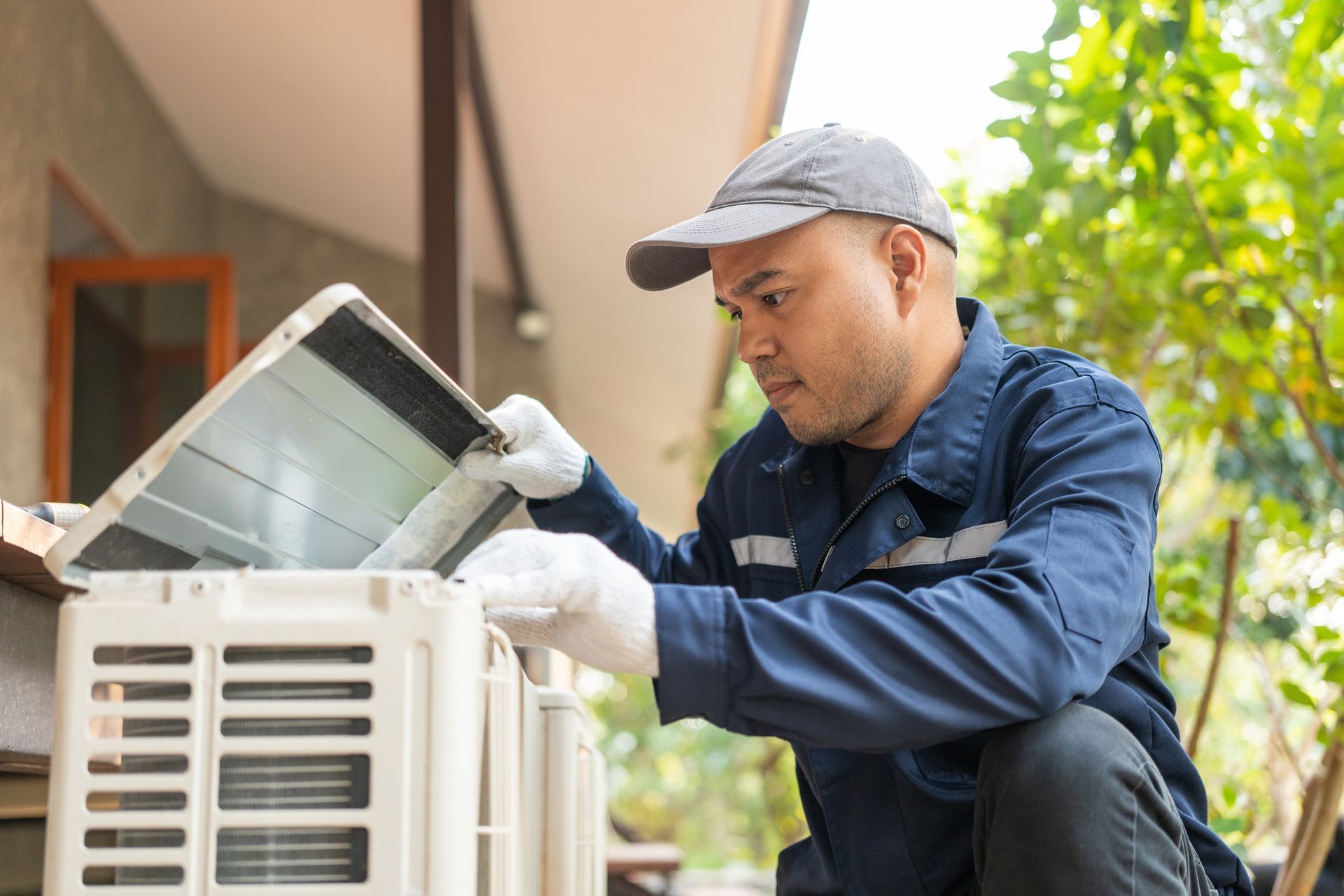 An air conditioner repairman checking an air conditioner outdoors. An air conditioner repairman checking an air conditioner outdoors.