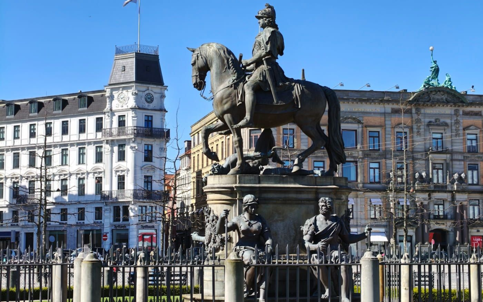 Hauptplatz Kopenhagen Equestrian statue in a city square with historic buildings under a clear blue sky