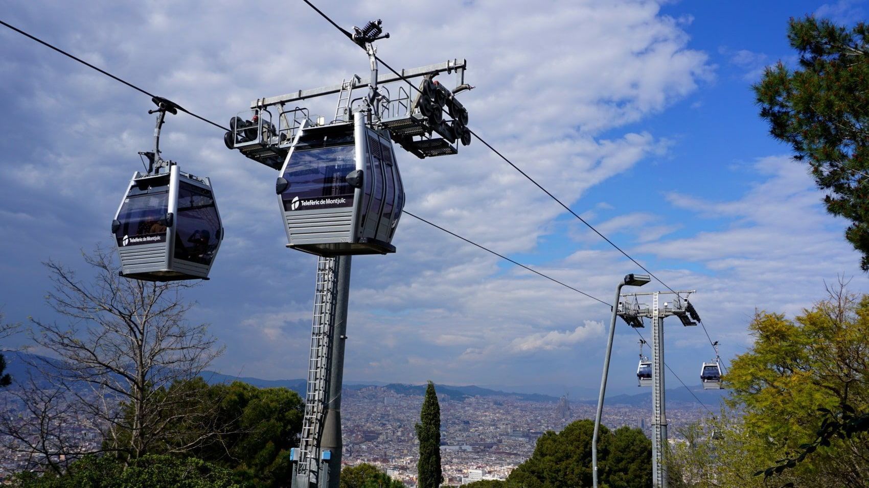 A cable car going up a hill with a city in the background