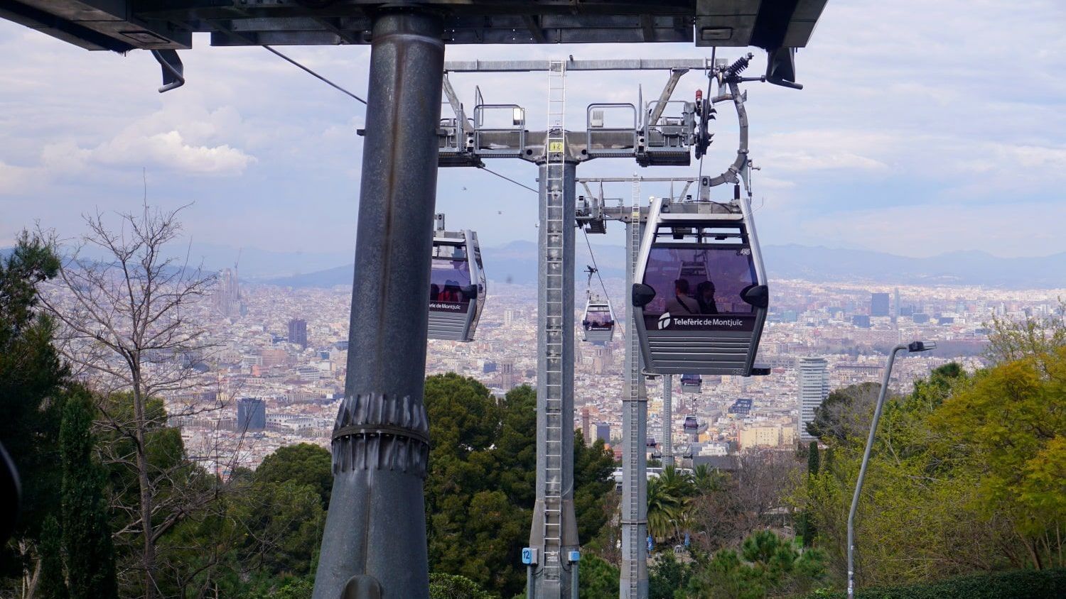 A cable car going up a hill with a city in the background
