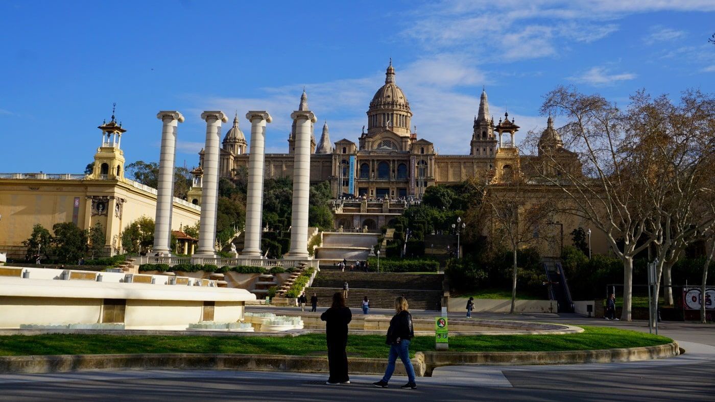 Two people standing in front of a large building with columns