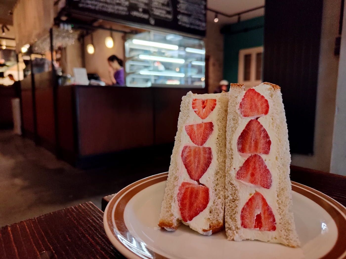 Sando in Berlin Two strawberry crepe slices on a plate in a cozy café interior