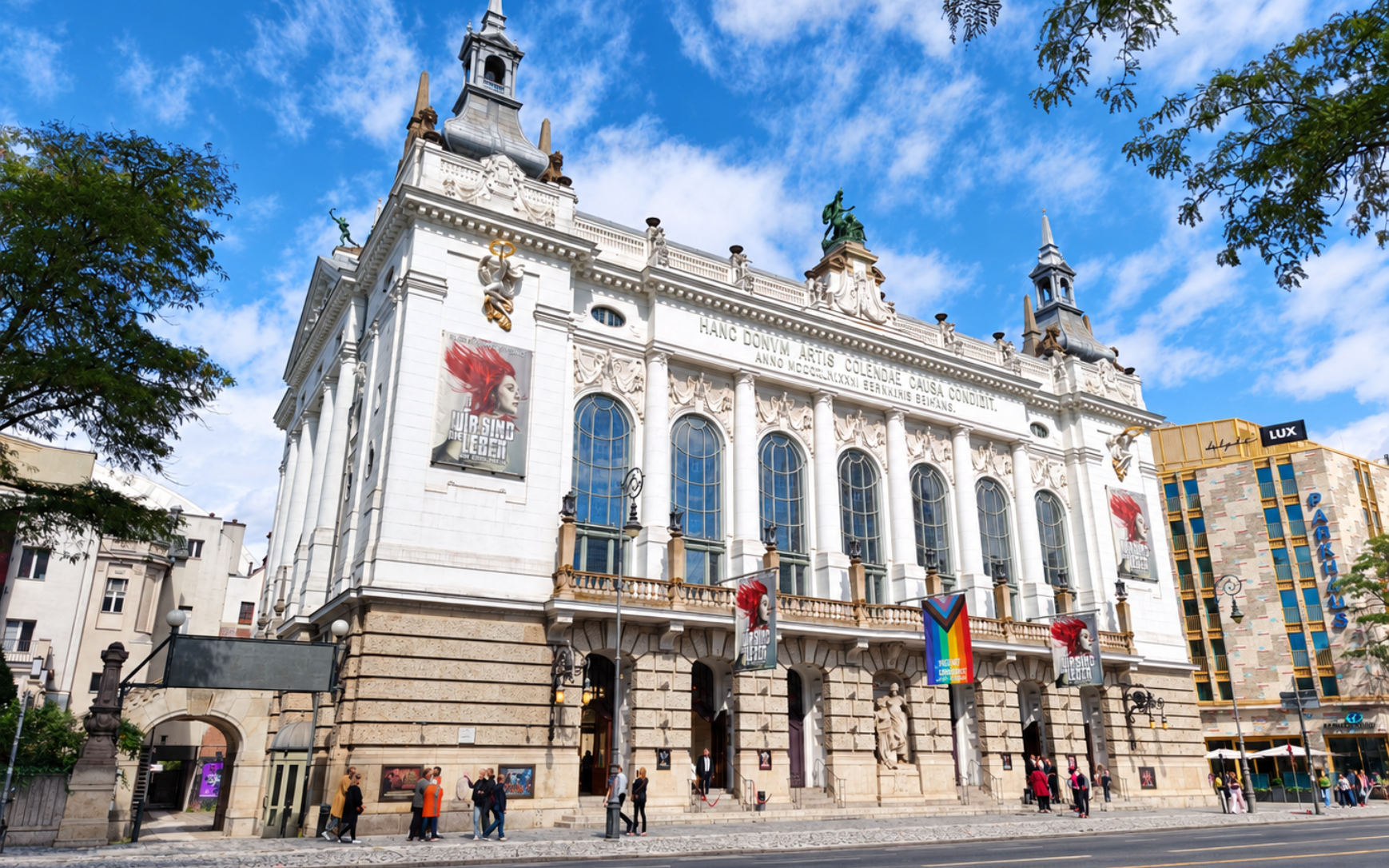 Theater des Westens Grand historic civic building with banners and rainbow flag on a sunny city street