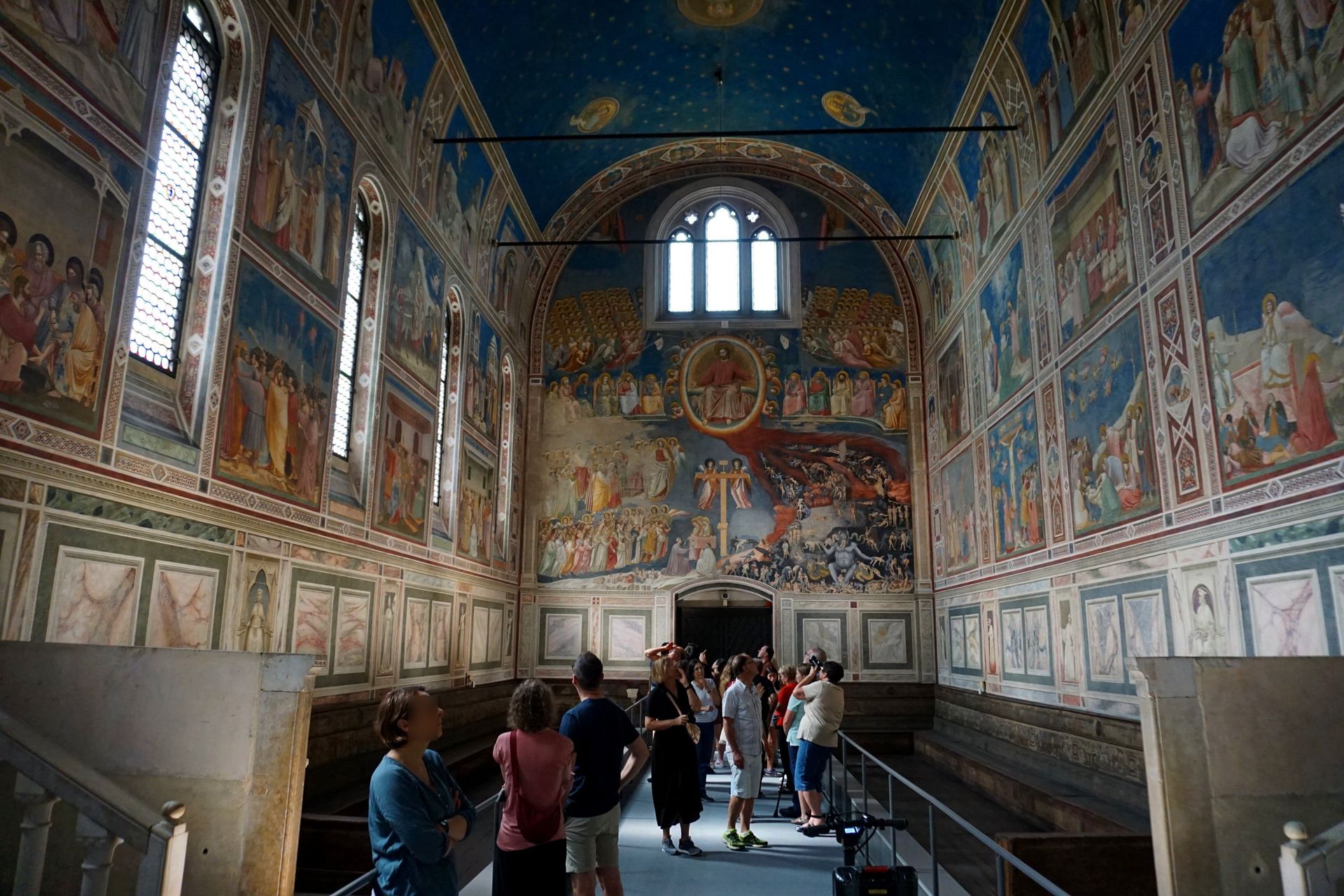 Cappella degli Scrovegni in Padova A group of people standing inside of a building with paintings on the walls