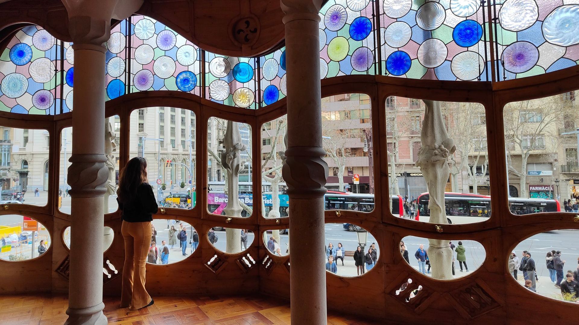 Casa Batlló Barcelona A woman stands in a room with stained glass windows