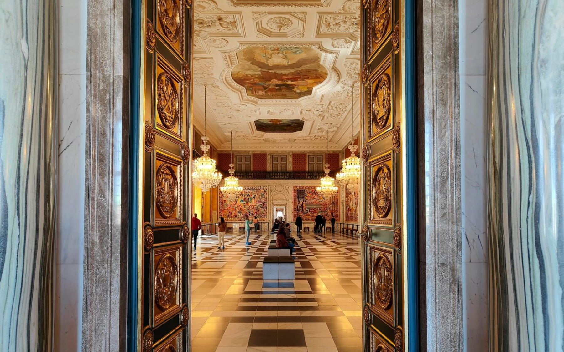 Christiansborg Kopenhagen Ornate palace hallway with gilded mirrors, chandeliers, and patterned marble floor