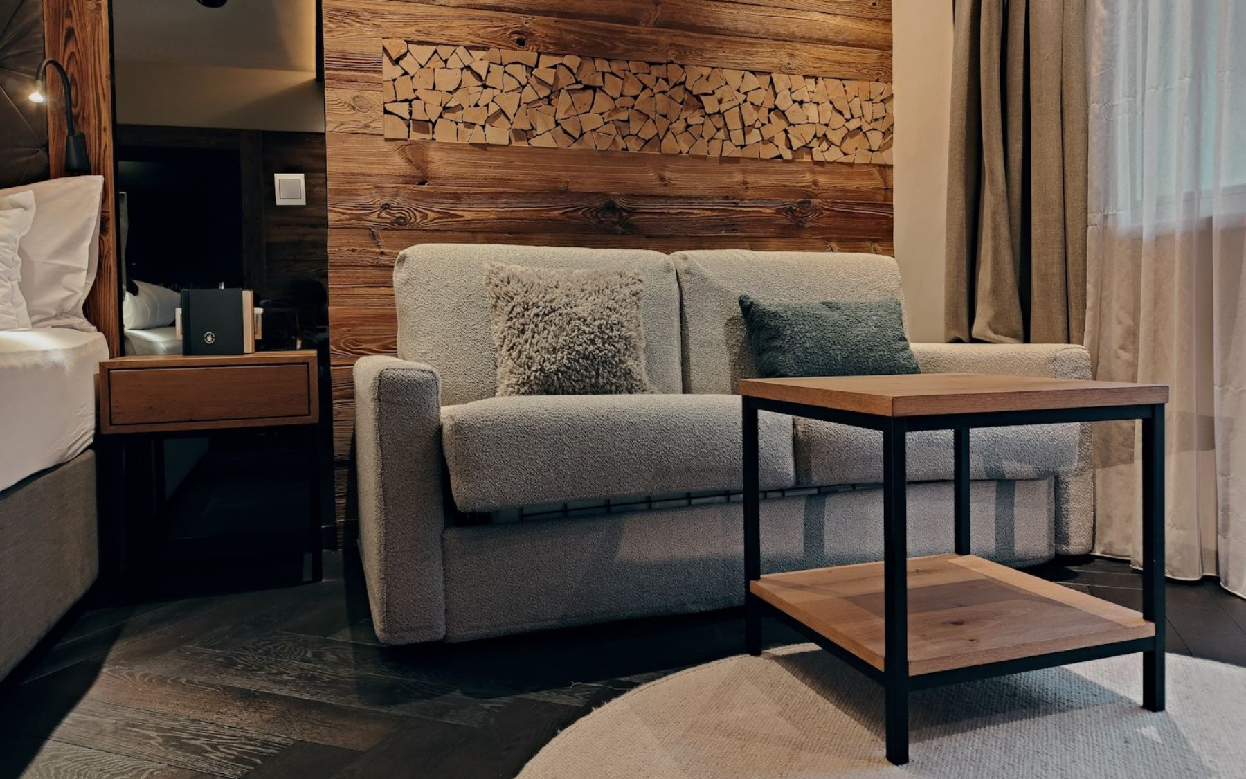 Das Innsbruck Cozy hotel room with a textured wood wall, sofa, and small wooden table.