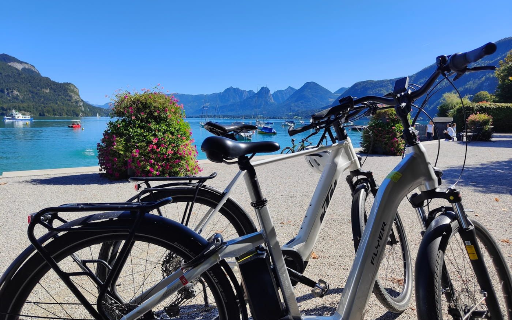 St. Gilgen Two bicycles parked by a sunny lakeside promenade with mountains in the distance