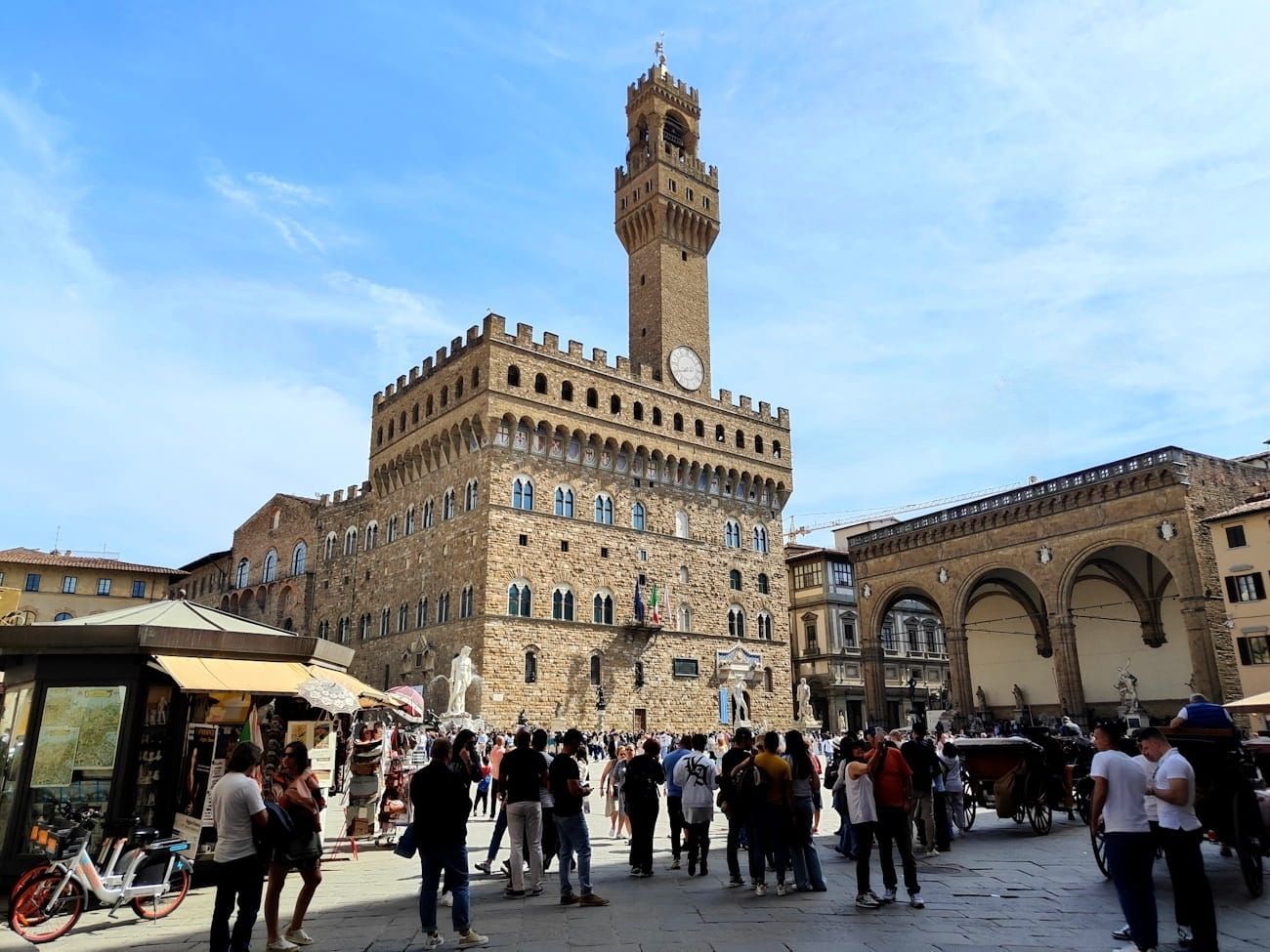 Palazzo Vecchio The Palazzo Vecchio rises over the bustling Piazza della Signoria in Florence, with tourists gathered in the square.