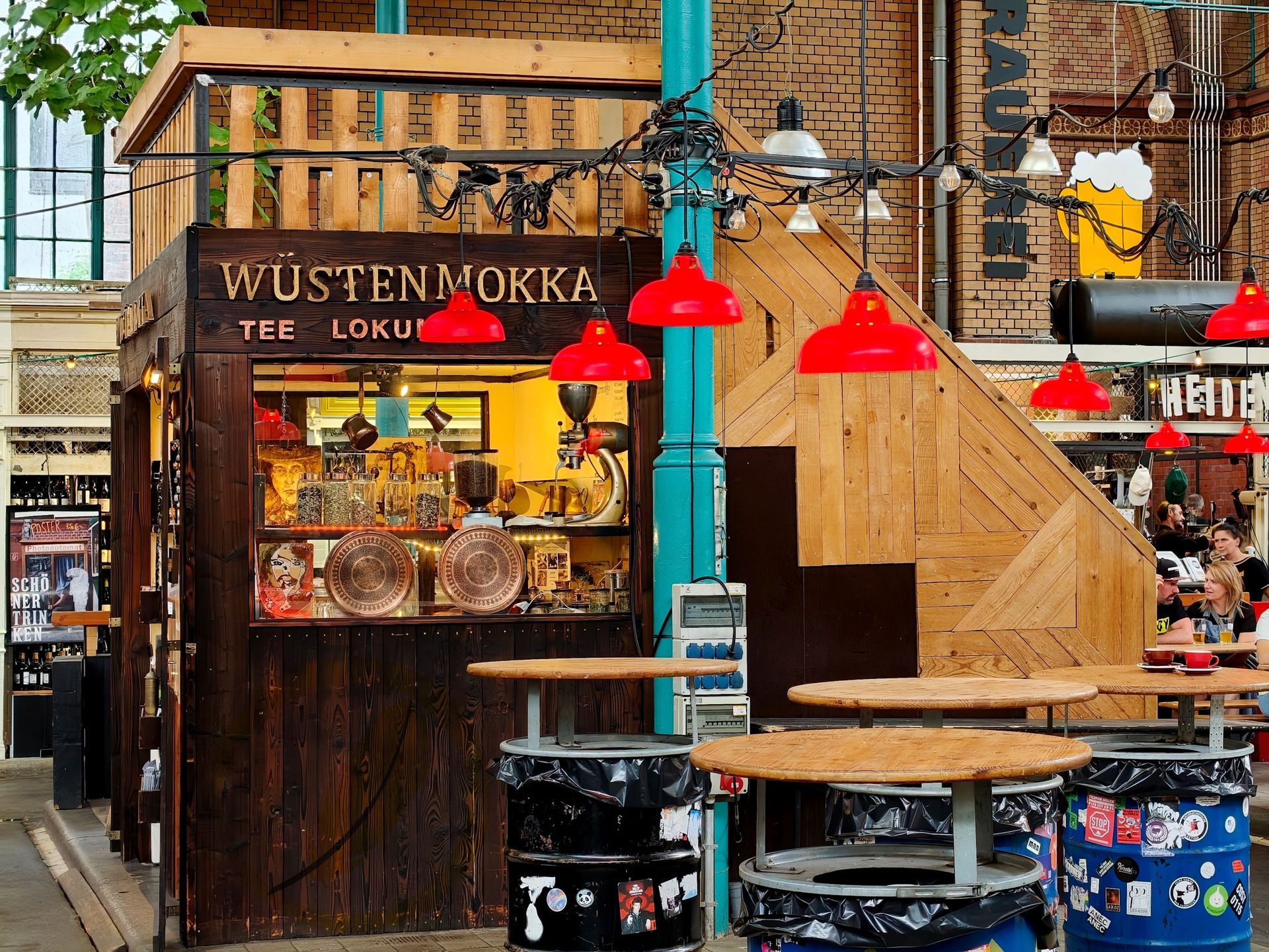 Wooden street food kiosk with red lamps and a table in a rainy market setting