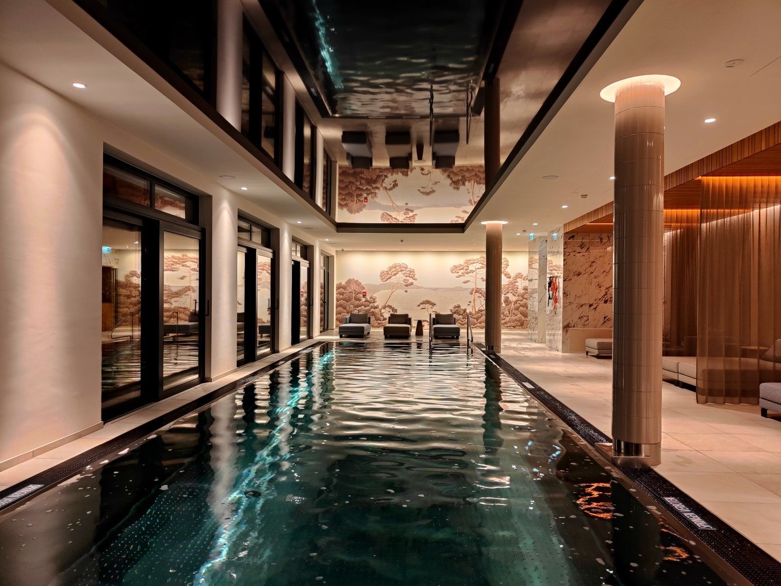 Grand Elisabeth Hotel SPA Indoor pool in a spa. Black pool, dark walls, and a patterned mural on the back wall.