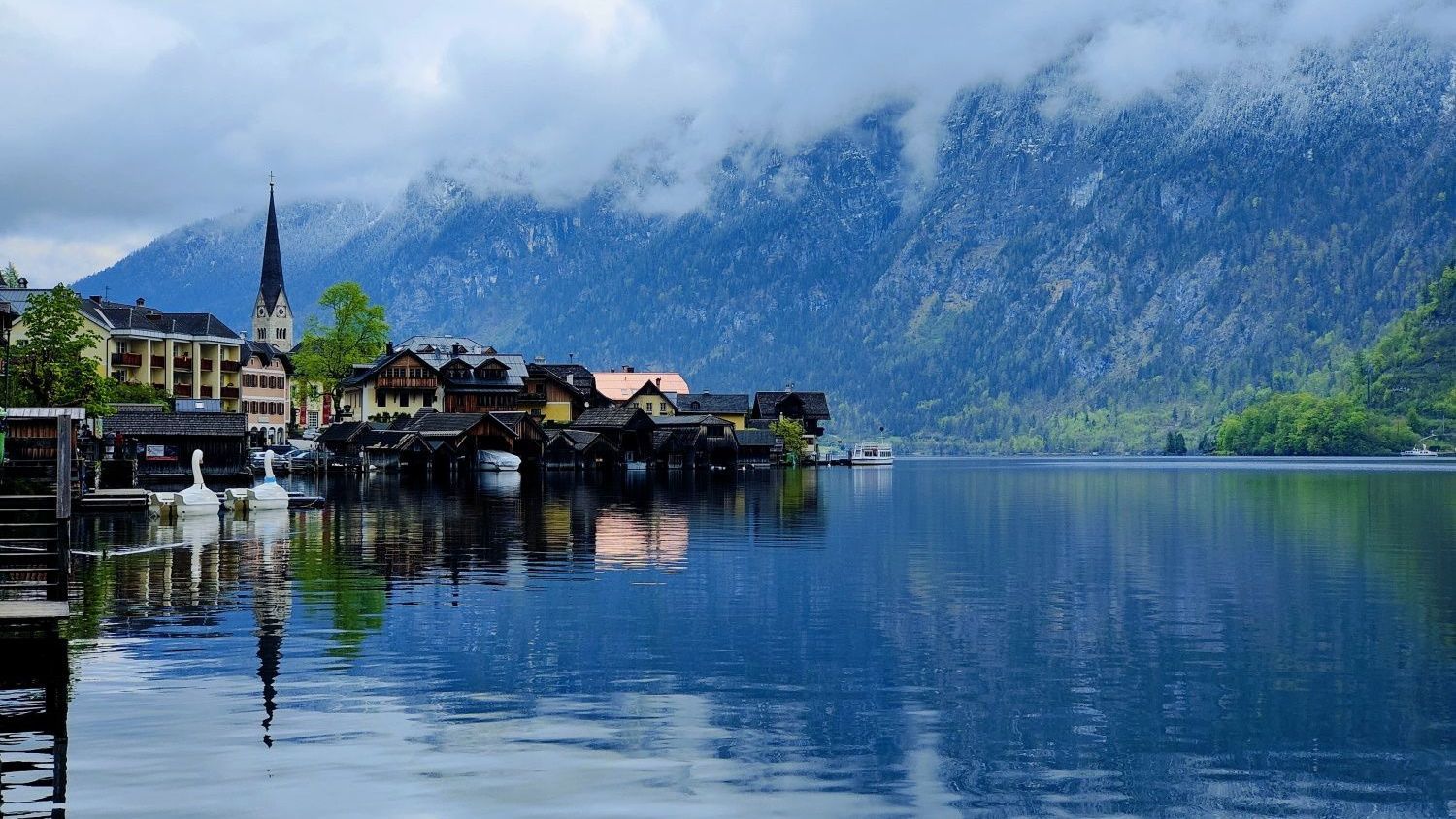 Hallstatt Österreich A small town sits on the shore of a lake with mountains in the background