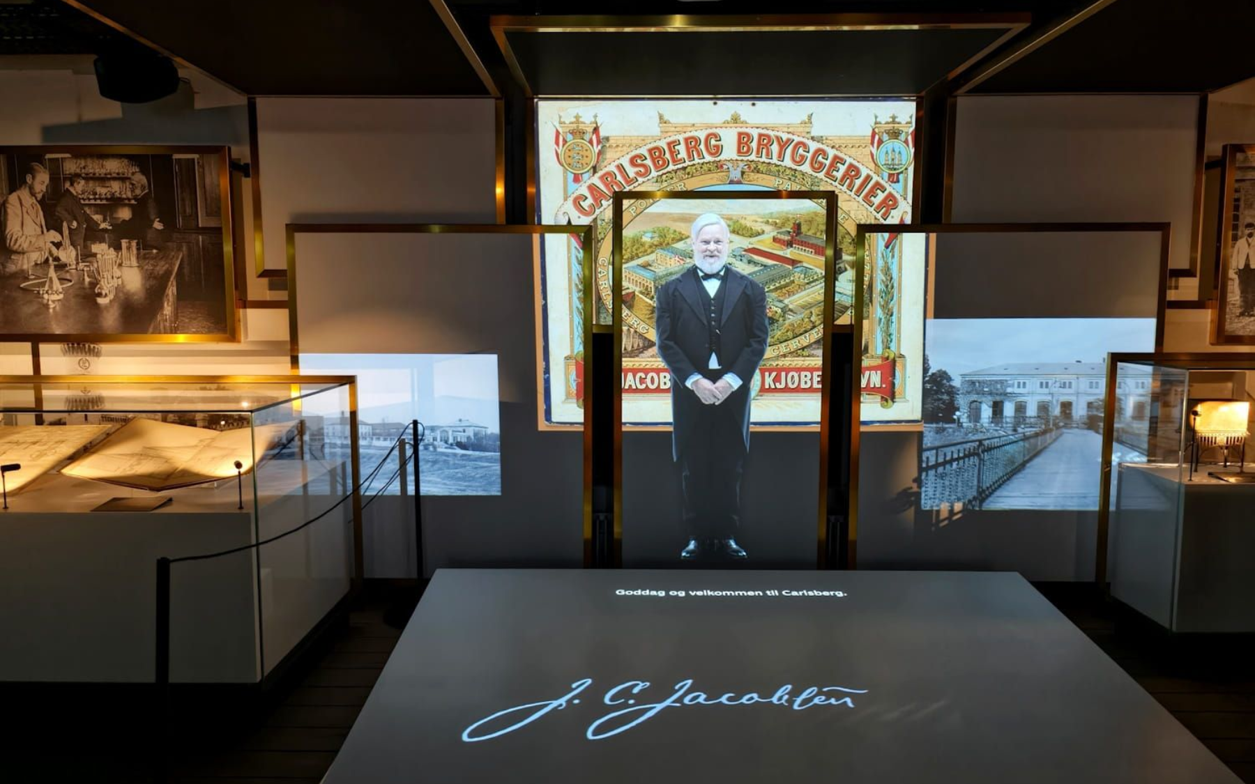 Home of Carlsberg Exhibit gallery with illuminated displays and a central mannequin in front of a decorative entrance.