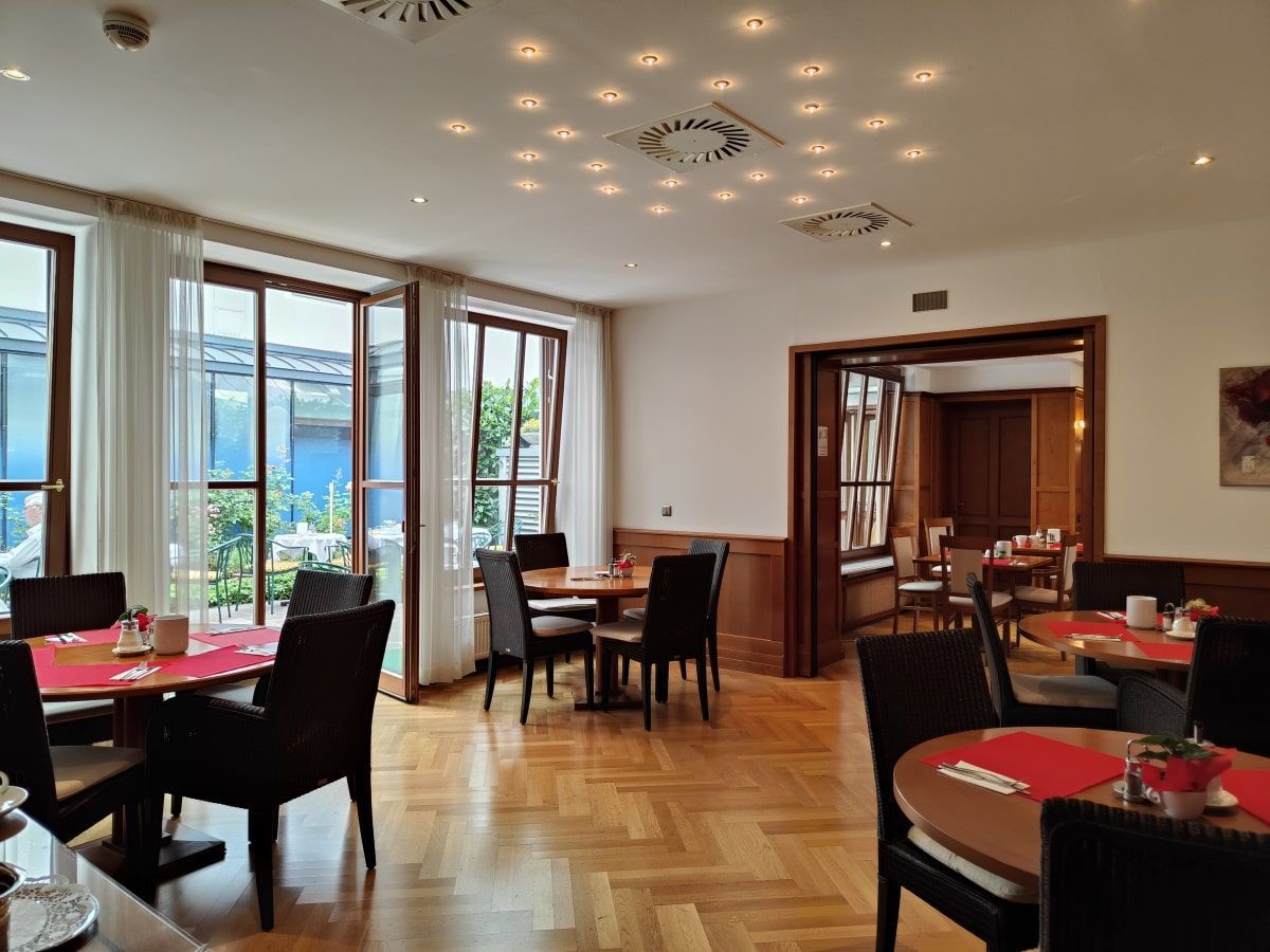 Hotel Gollner Frühstück A restaurant with tables and chairs and a clock on the ceiling