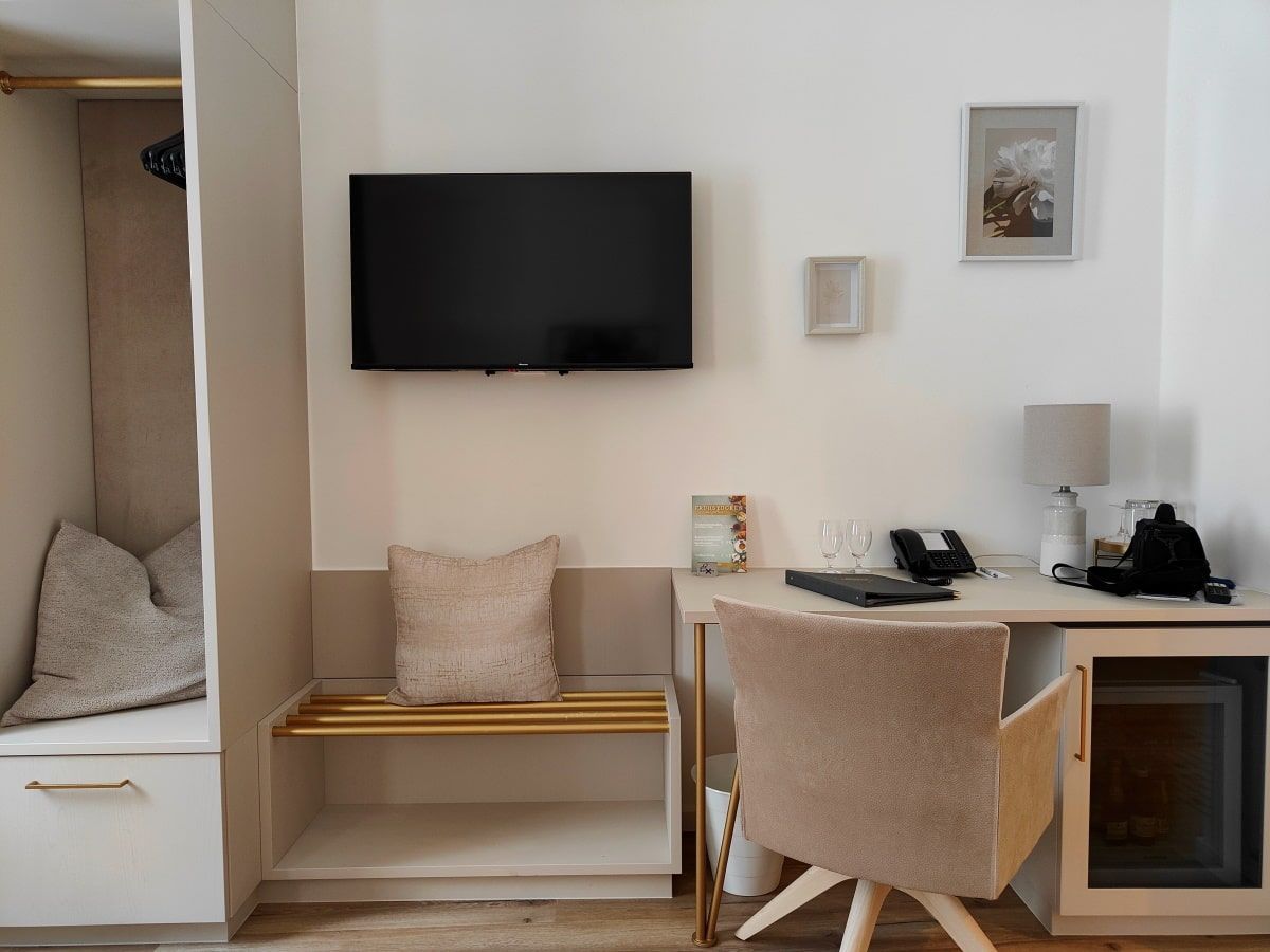 Hotel Gollner A room with a desk chair and a flat screen tv
