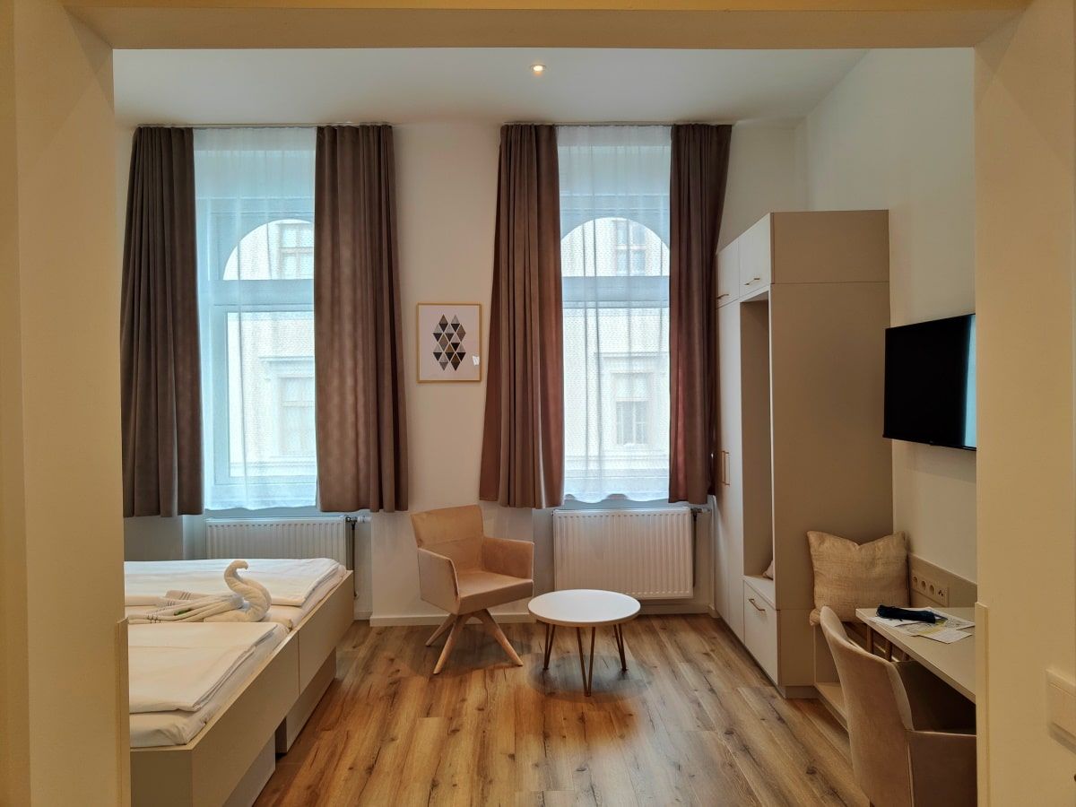 Hotel Gollner A bedroom with two beds a chair and a table