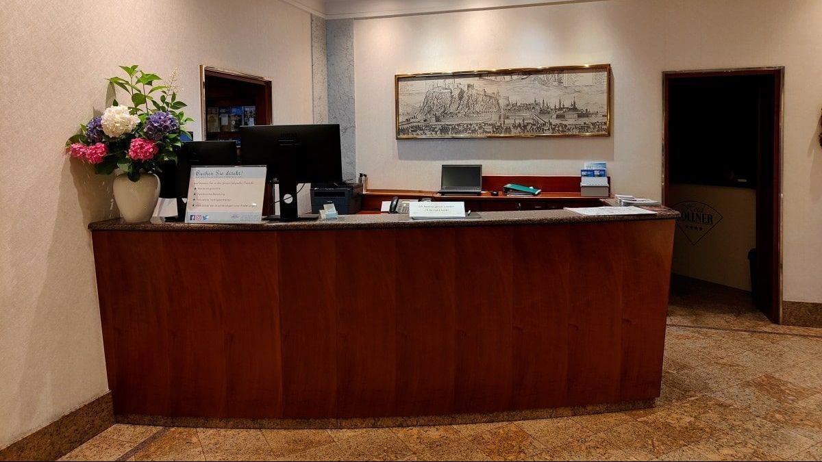 Hotel Gollner Rezeption A reception desk in a hotel with flowers on it