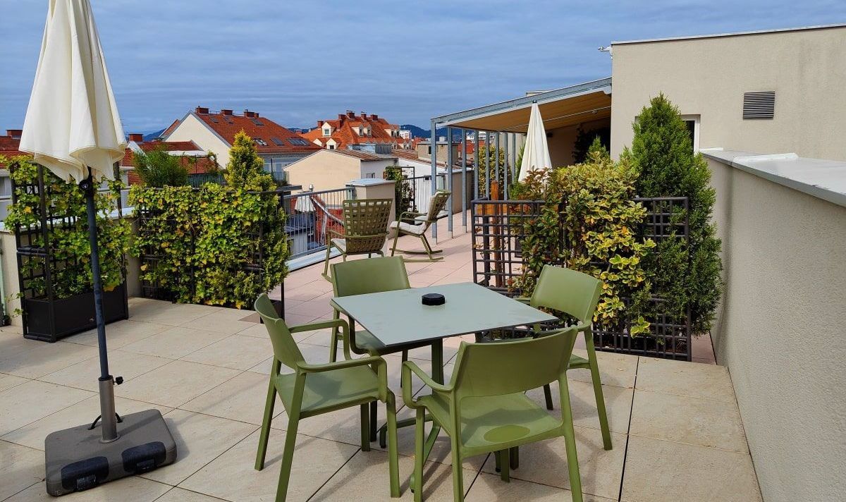 Hotel Gollner A patio with a table and chairs and an umbrella