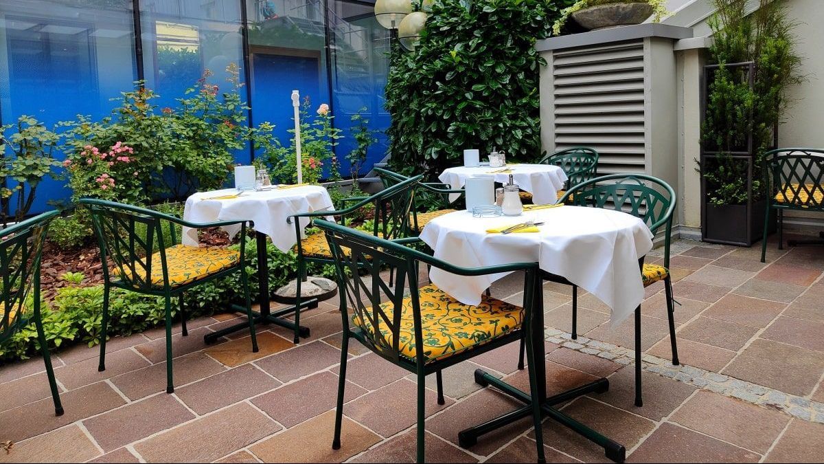 Hotel Gollner Graz A patio with tables and chairs with yellow cushions